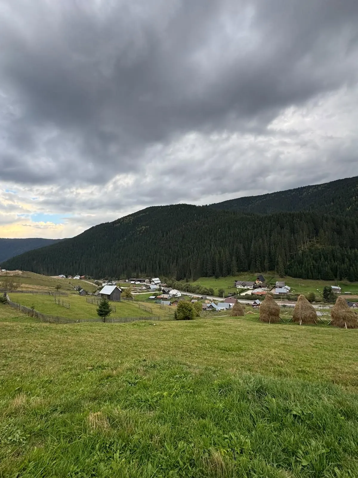 Valea din Gura Glodului cu căpițe de fân și nori